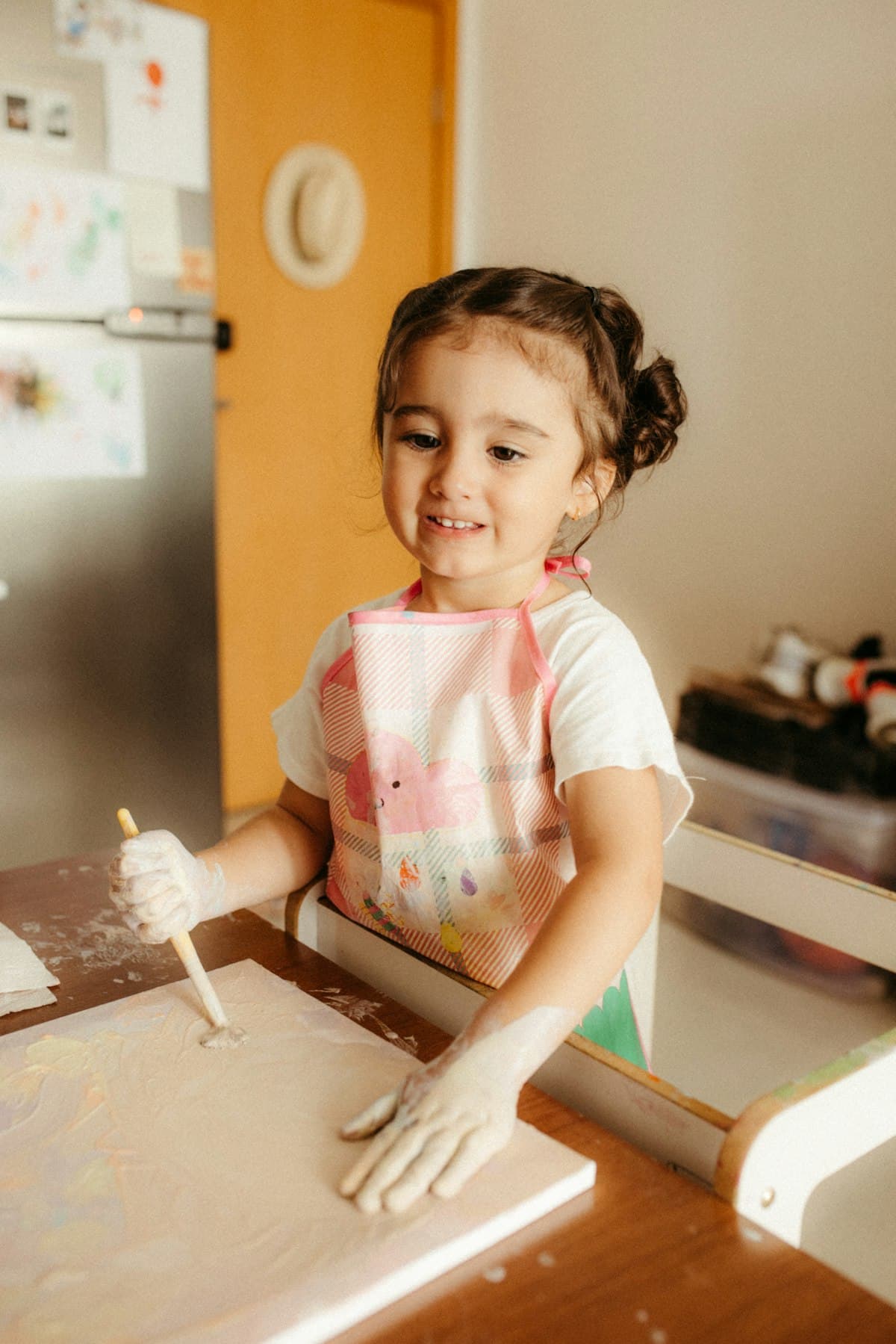 Joyful child creating art with paint, natural light